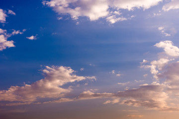 A tranquil sky at sunset with soft clouds illuminated by warm tones, creating a peaceful and serene atmosphere.