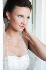 Bride fixes a necklace on the wedding day