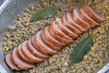 slices of cotechino in soup of lentils