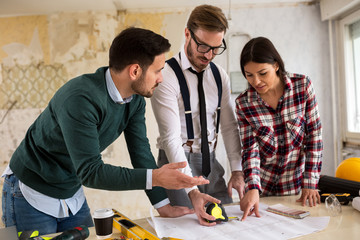 Three  architects checking blueprint