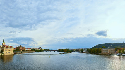 Obraz premium Praha panorama, The view over the Vltava river, Charles bridge and white swans from Mala Strana in Prague, Czech Republic, on a clear sunny winter day