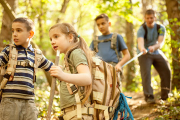Children scouts and father explore the beautiful forest