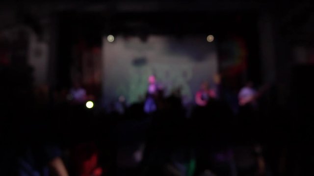 A crowd of people dancing at a rock concert. blurred image. Out of focus