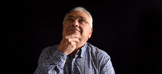 Obraz premium Pensative man on black background