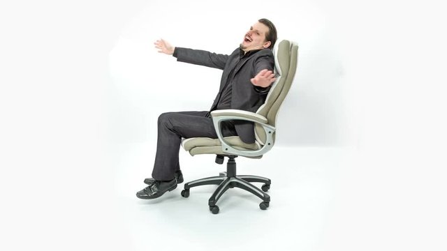 The boss is smiling and spinning around in his chair. He is having a good time. His arms are spread out.