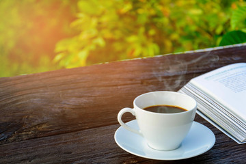 coffee cup clock and news paper on old wooden table