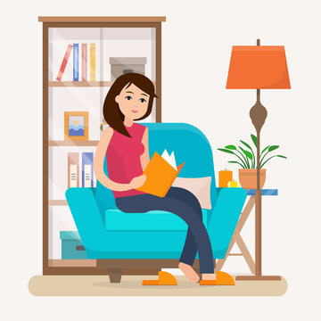 Young woman reading book on chair at home.