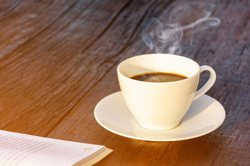 coffee cup clock and news paper on old wooden table