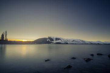 Fototapeta premium Beautiful dusk hour at Lake Tekapo, New Zealand. During winter time, mountain at the back are covered with snow and make the view more beautiful.