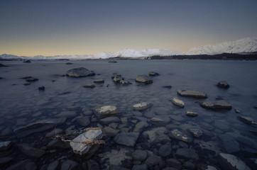 Beautiful dusk hour at Lake Tekapo, New Zealand. During winter time, mountain at the back are covered with snow and make the view more beautiful.