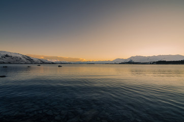 Beautiful dusk hour at Lake Tekapo, New Zealand. During winter time, mountain at the back are covered with snow and make the view more beautiful.