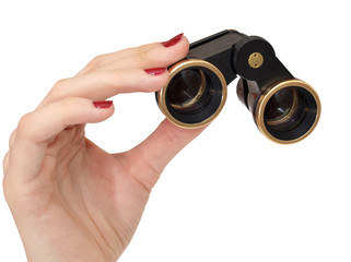 Old theatrical binoculars in a female hand on white background