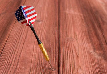Dart with US Flag Flight, stuck in a mahogany board
