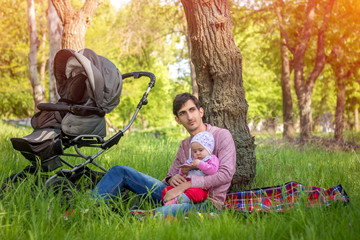 Young father with baby outdoors in park