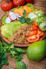 
 Buddha Quinoa bowl of mixed vegetable on the wooden table.