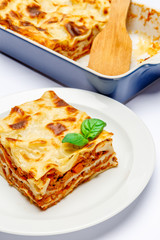Portion of tasty lasagna isolated on white