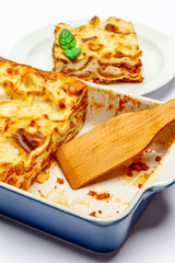 Portion of tasty lasagna isolated on white