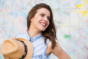 Pretty woman standing against bright painted wall