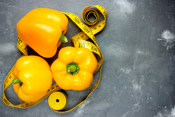 Ripe juicy yellow pepper and measuring tape on the table