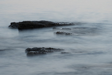 Fototapeta na wymiar Rocks in the sea with smooth flowing water