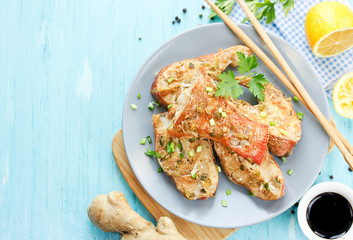 Steamed snapper (pacific ocean perch, sea bass, ruby perch) with soy sauce, lemon, ginger and parsley in Asian style
