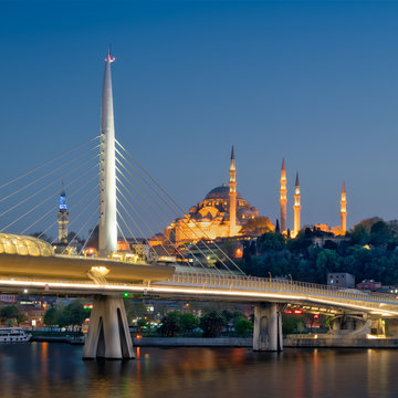 Night shot of Golden Horn Metro Bridge (Halic Bridge) overlapping Suleymaniye Mosque, Istanbul, Turkey