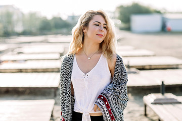 Obraz premium Blonde girl on the beach of the sandy beach by the sea