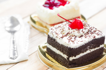 Cake with chocolate and strawberry cake on wood background.