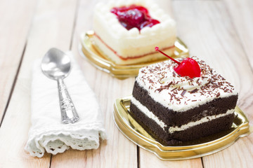 Cake with chocolate and strawberry cake on wood background.