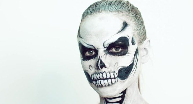Girl with creative halloween face art on white background.