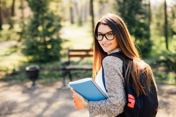 Obraz premium Pretty student smiling at camera outside on campus at the university