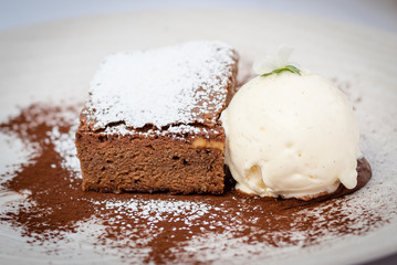 Chocolate brownie dessert with vanilla Ice Cream to the side, served at a restaurant somewhere at Madrid, Spain, 2017