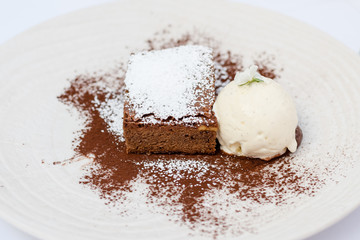 Chocolate brownie dessert with vanilla Ice Cream to the side, served at a restaurant somewhere at Madrid, Spain, 2017