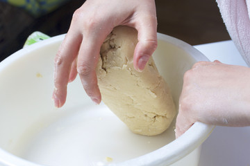 Pie with stuffing from cottage cheese and apple jam. The woman kneads the dough.