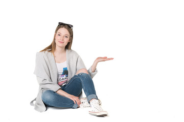 Young beautiful girl in casual clothes showing something, studio shot isolated, pure white background