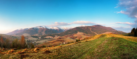 Panorama view of snow capped mountain peaks in spring