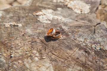Gold wedding rings on a wooden texture