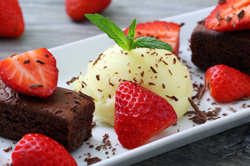 gelato con fragole e dolce al cioccolato  su sfondo grigio