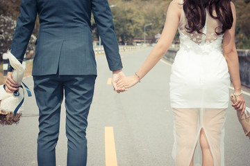 Young married couple holding hands walk bright future.