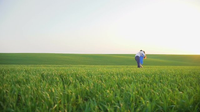 He and she running to each other and spining on the spring wheat field