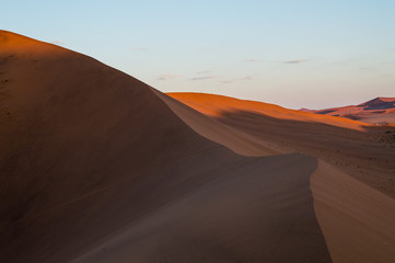 Fototapeta na wymiar Climbing Big Daddy Dune during Sunrise, Desert Landscape at Dawn, Sossusvlei, Namibia