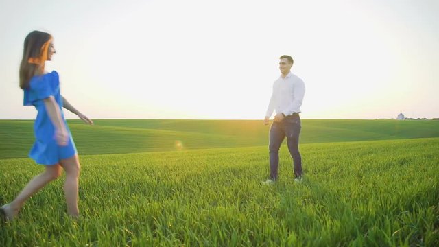 He and she running to each other and spining on the spring wheat field