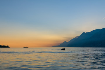 Fototapeta premium Evening landscape with couple on the boat