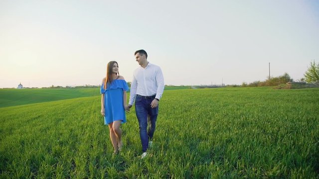 Couple in love walking in embraces on the wheat field and looking to each other
