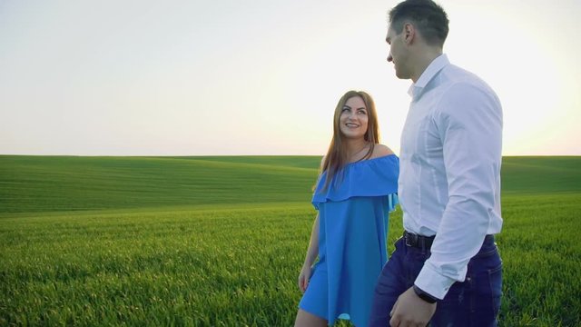 Couple in love walking in embraces on the wheat field and looking to each other