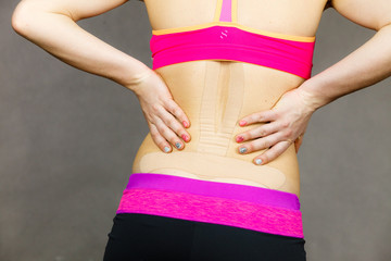 Woman with medical kinesio taping on back