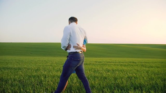 Couple in love walking in embraces on the wheat field and looking to each other