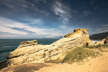 sandstone cliff with partly cloudy skies