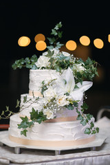 Vertical shot of a white wedding cake with fresh flowers decoration