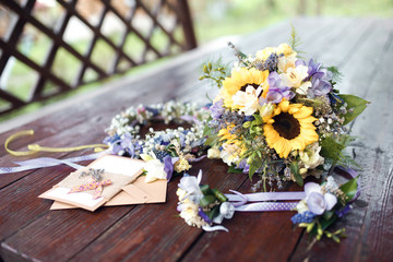 Closeup shot of the wedding bouquet, wreath and invitations  at daylight